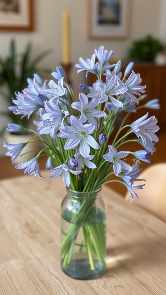 A bouquet of agapanthus flowers in a glass vase on a wooden table.