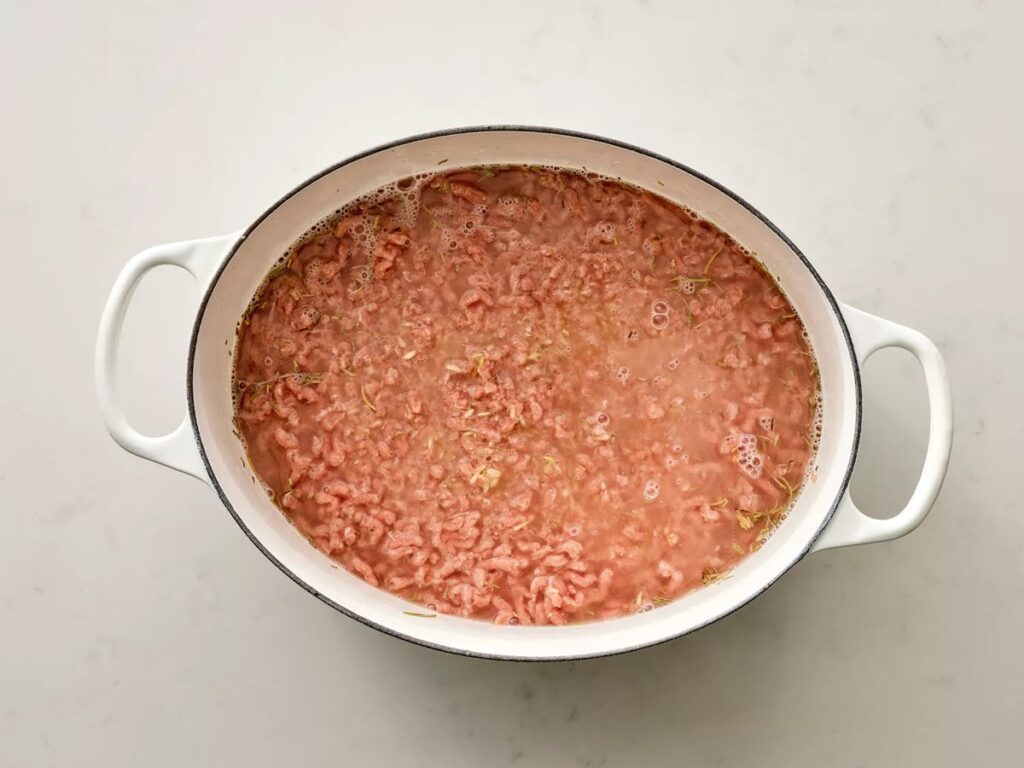 Simmering Ground Meat in a White Dutch Oven - Homemade dog food recipes