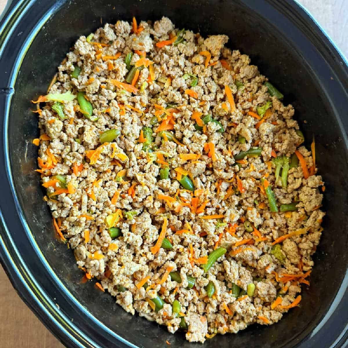 Cooked Mix in a Dark Oval Slow Cooker - Homemade dog food recipes